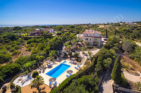 aerial view of villa with pool and sea in the distance