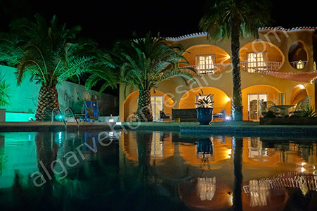 VIlla at night with pool and palm trees