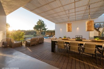 Covered terrace with decking and pool at sunset