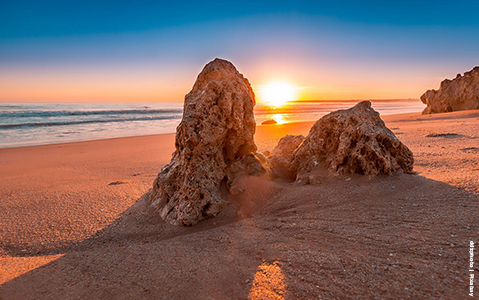 sunset from algarve beach with rock formation