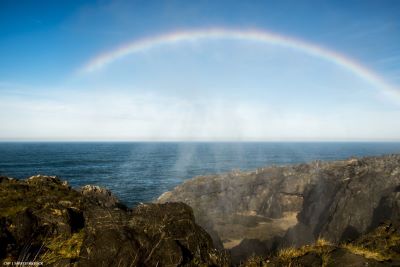 Rainbow over ocean seen from cliffs