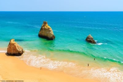 Algarve beach with a few people swimming