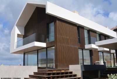 Newly-built villa with floor to ceiling glass and wooden panelling on exterior walls