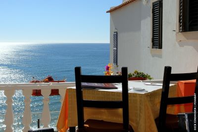 View from terrace with table and chair in foreground looking out to sea