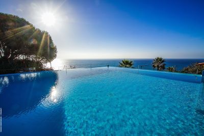 View across seimming pool and garden to the ocean