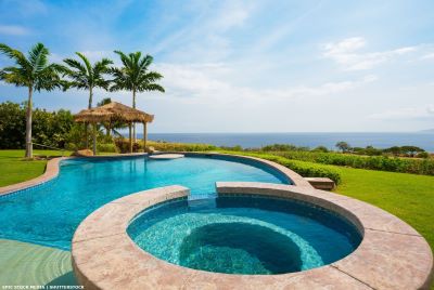 Pool and hot tub in garden with view to the ocean