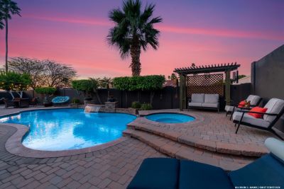 Pool and hot tub with surrounding terrace and exterior furniture