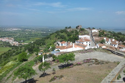 View from high on a hill with country building in front across the plains of alentejo, Portugal
